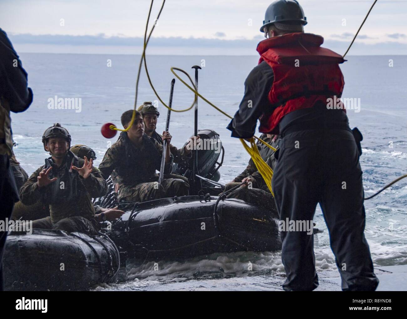 PHILIPPINE SEA (March 19, 2017) ) Deck department Sailors recover Reconnaissance Marines, assigned to the Maritime Raid Force (MRF) of the 31st Marine Expeditionary Unit (MEU), on combat rubber raiding crafts (CRRC) in the well deck of amphibious assault ship USS Bonhomme Richard (LHD 6) following a helo cast exercise. A helo cast is a method used to insert reconnaissance and surveillance teams for amphibious reconnaissance missions requiring small boat operations. Bonhomme Richard, flagship of the Bonhomme Richard Expeditionary Strike Group, with embarked 31st MEU, is on a routine patrol, ope Stock Photo