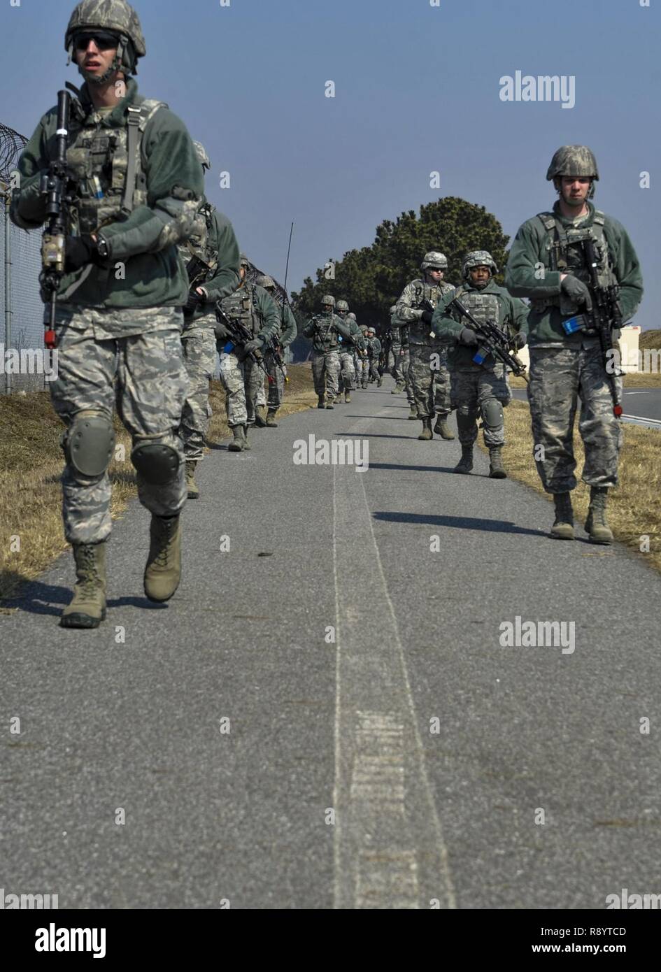 U.S. Air Force 8th Security Forces Squadron members march in a tactical staggered formation while observing their surroundings during a field training exercise at Kunsan Air Base, Republic of Korea, March 17, 2017. Tactical movements allow for military members to scan effectively and keep a safe distance between each other. Stock Photo