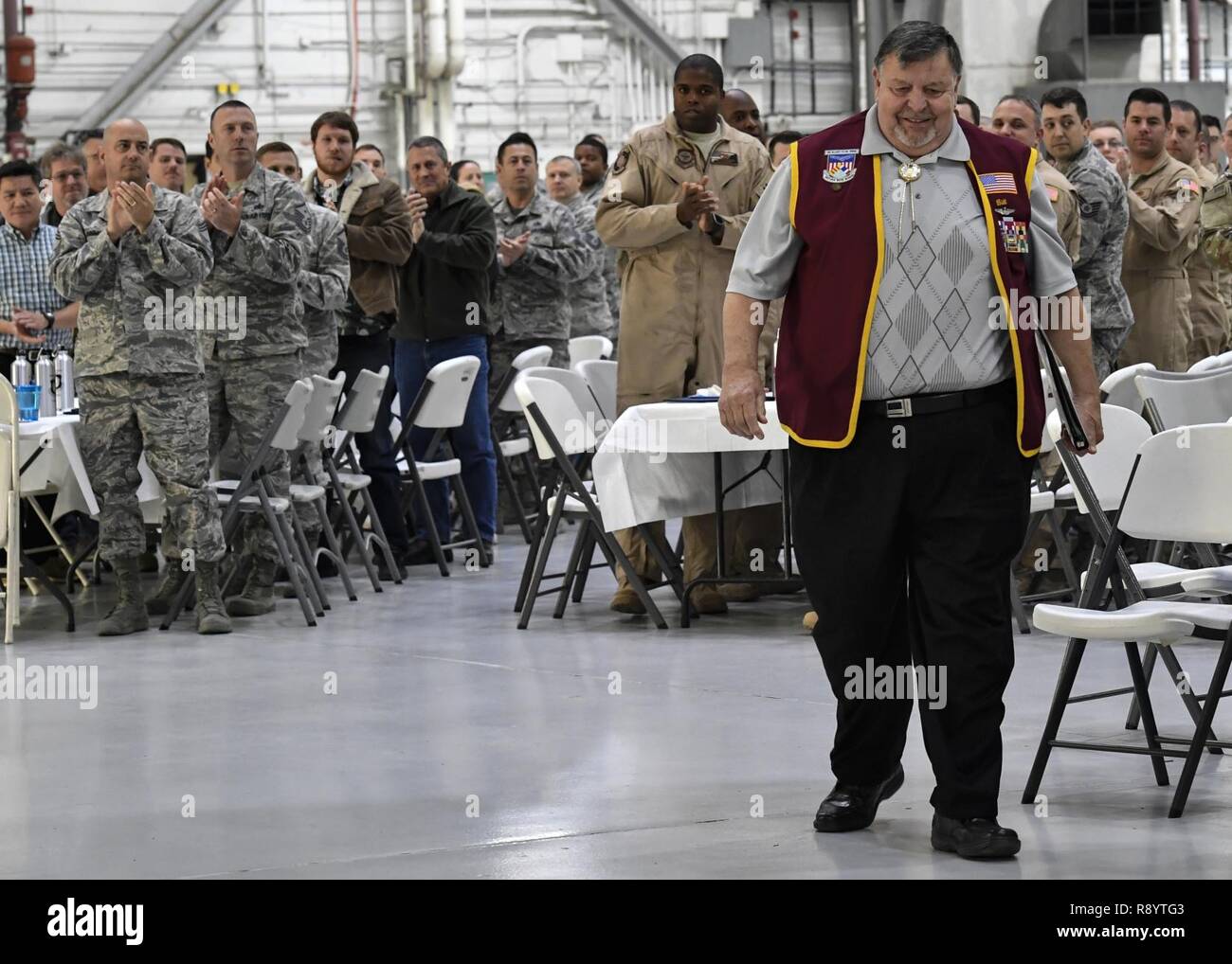 Members of the 437th Maintenance Group cheer as retired U.S. Air Force Capt. William Robinson, longest surviving enlisted prisoner of war, makes his way to the stage during an award ceremony here, March 17, 2017. Robinson was a POW for nearly eight years before being released. Now, Robinson speaks about his experience with community and military members across the country. Stock Photo