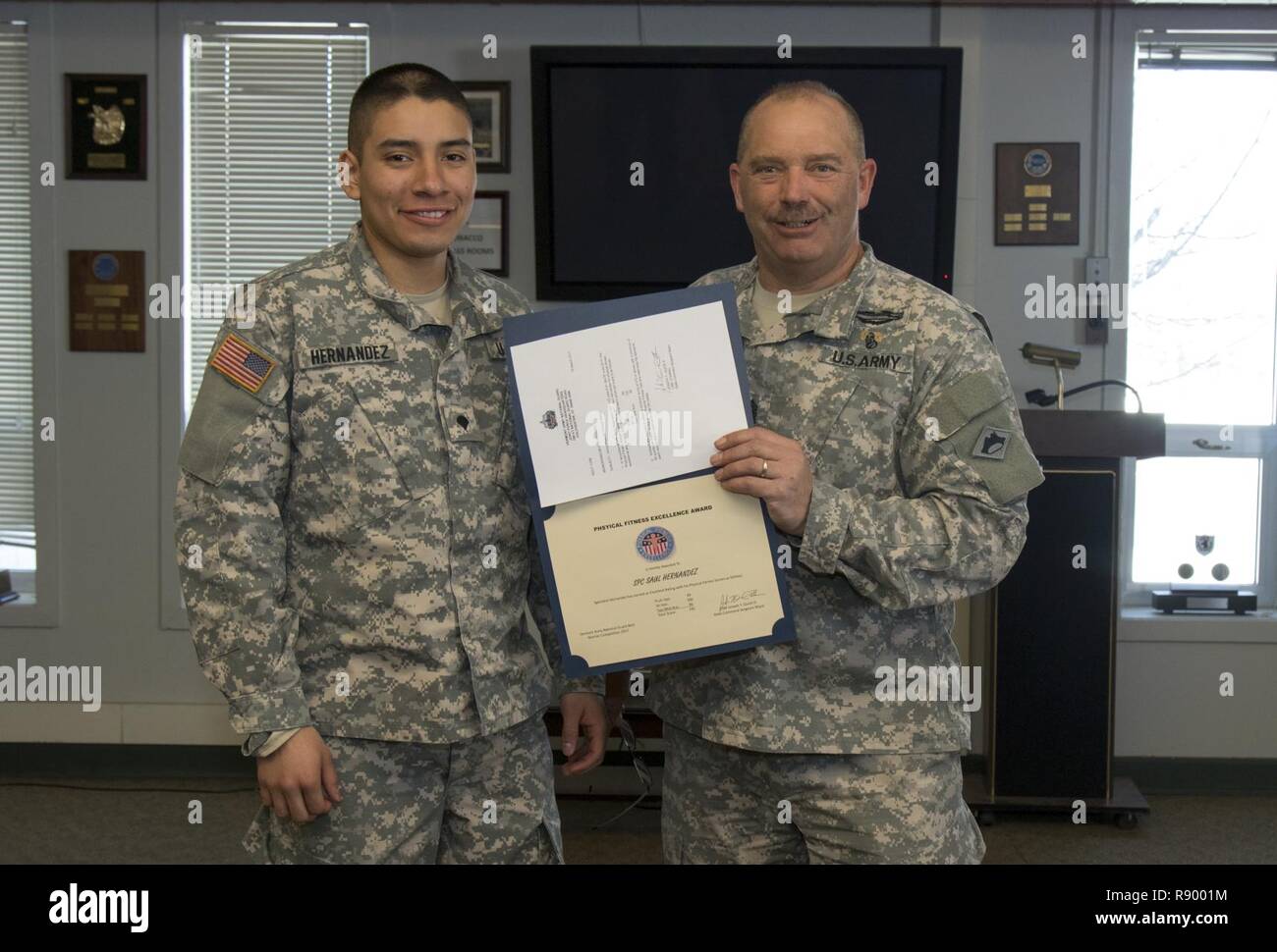 U.S. Army Command Sgt. Maj. Joseph T. Quick, state command sergeant major, Vermont National Guard, congratulates Spc. Saul Hernandez, Alpha Company, 3rd Battalion, 172nd Infantry Regiment, 86th Infantry Brigade Combat Team (Mountain), Vermont National Guard, with the Physical Fitness Excellence Award at Camp Ethan Allen Training Site, Jericho, Vt., March 19, 2017. Hernandez competed in Vermont’s Best Warrior Competition, placing third overall for the junior enlisted. Stock Photo