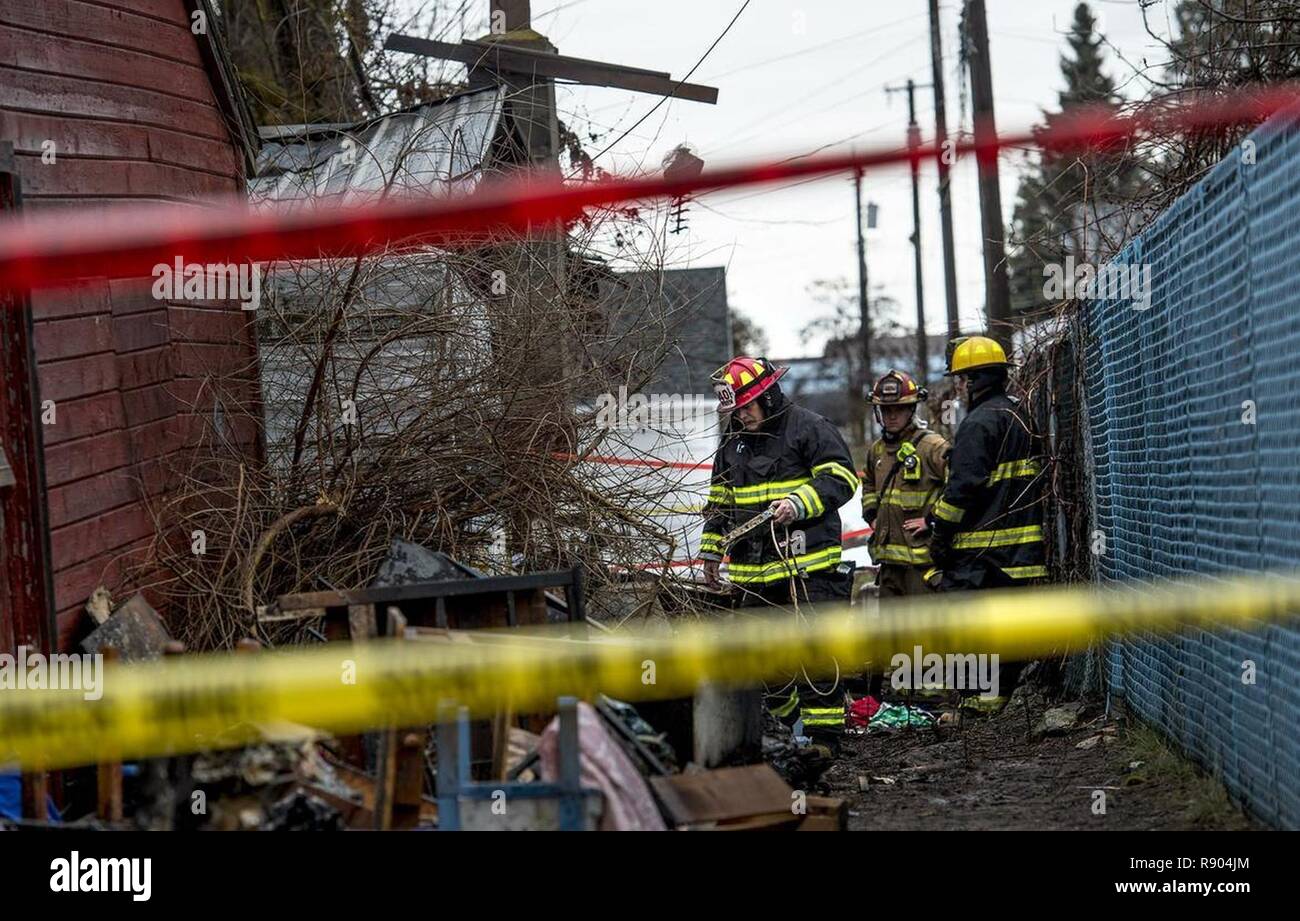 Firefighters sift through debris at a home in Medical Lake after a woman was found dead in the one-story structure that burned early Tuesday, March 14, 2017. Firefighters were called to the home near 703 E. Barker at 12:45 a.m., said Spokane County Sheriffs Deputy Mark Gregory. When they arrived on scene, firefighters saw large amounts of fire and smoke coming from the home. They were hampered by a large amount of clutter inside and out, Gregory said. While fighting the fire, they learned that a woman might still be inside, Gregory said. But firefighters were unable to enter the structure. Fir Stock Photo