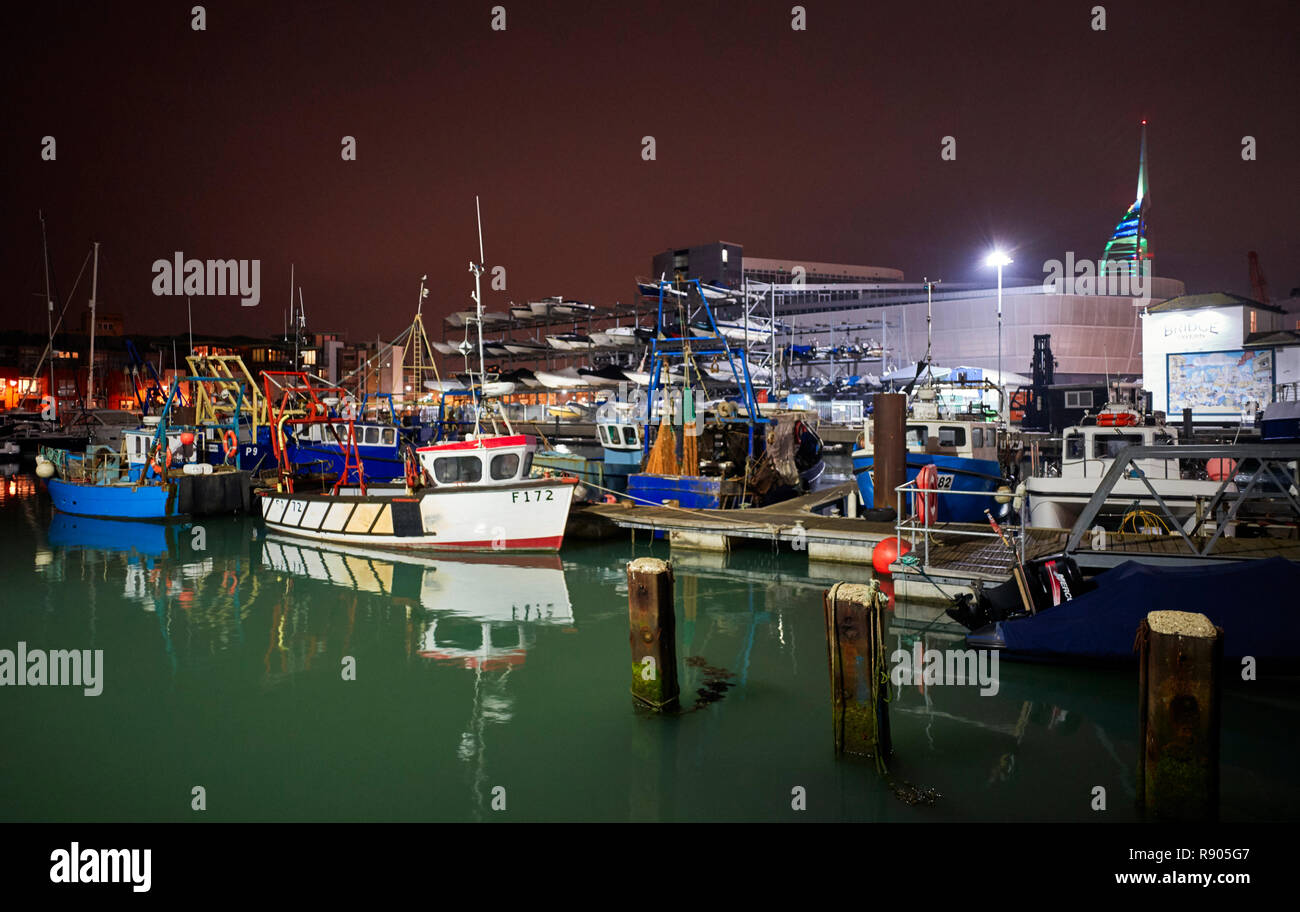 Camber Docks in Portsmouth at night with small inshore fishing vessels in foreground Stock Photo