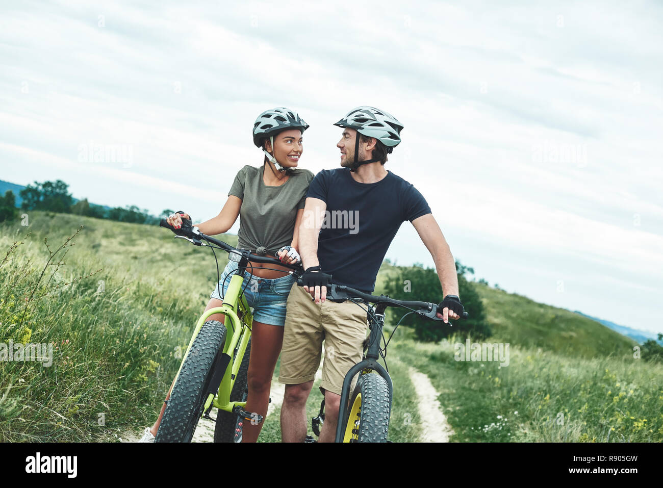 So close to each other. Man in protection and fatbike is staring at his girlfriend Stock Photo
