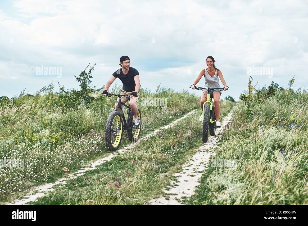 A man and a woman are laughing and riding fatbikes Stock Photo
