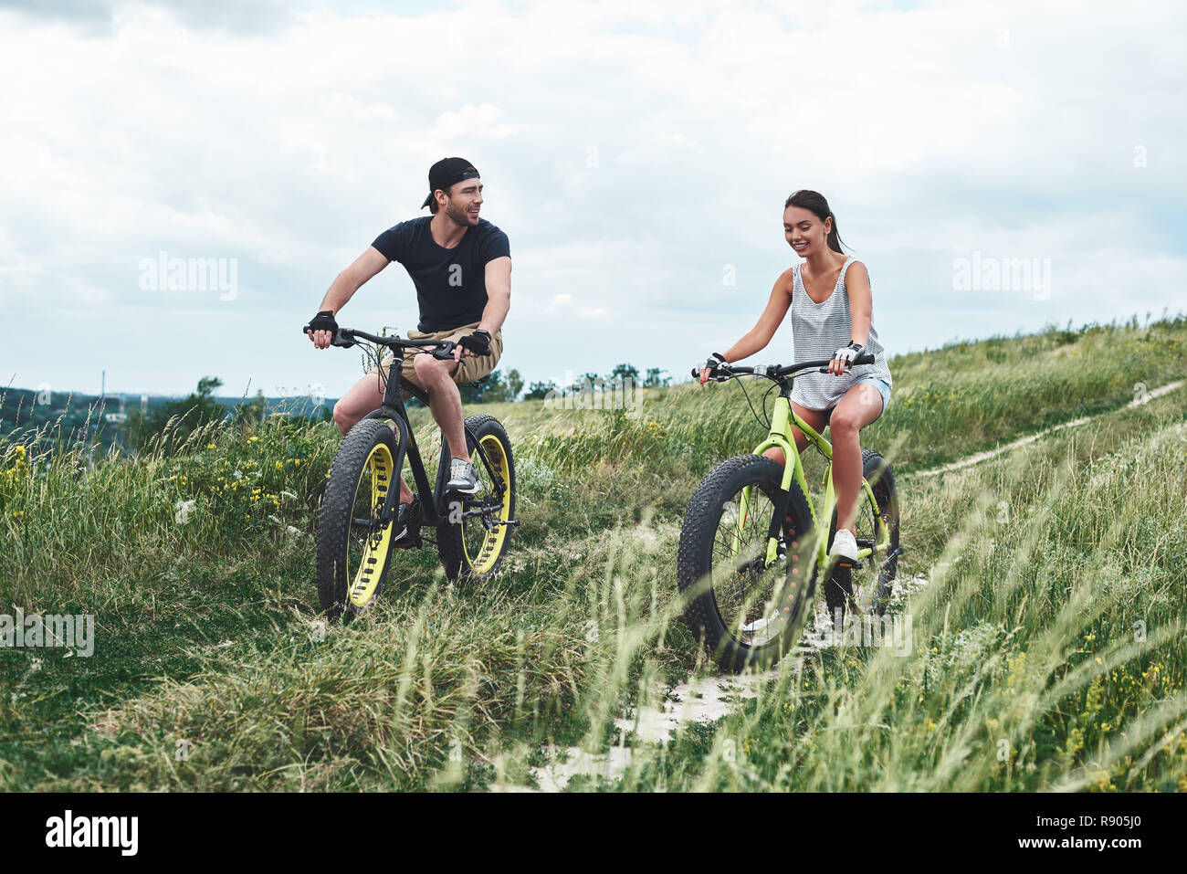 A man and a woman are laughing and riding fatbikes Stock Photo