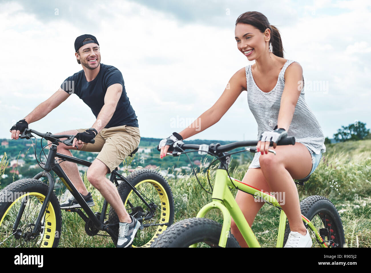 A man and a woman are laughing and riding fatbikes. Close up Stock Photo