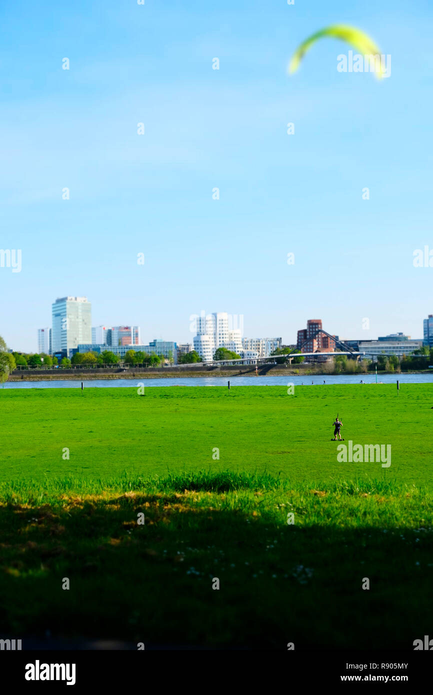 Kite skateboarder on the  meadows of the left rhine river bank in Dusseldorf, Germany Stock Photo