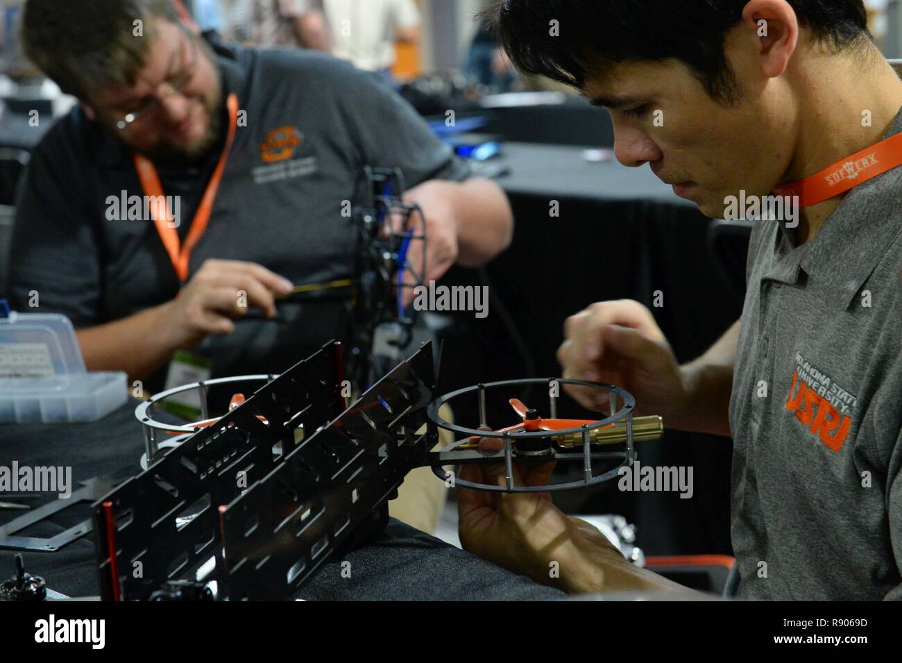 Dillon Nelson, right, and Dane Johnson, research engineers from the Oklahoma State University Unmanned Systems Research Institute, assemble collision resistant drones during the ThunderDrone Rodeo at the newest SOFWERX facility in Tampa, Fla., Nov. 1, 2017. ThunderDrone is a U.S. Special Operations Command initiative dedicated to drone prototyping, which focuses on exploring drone technologies through idea formation, testing, and demonstration. Stock Photo