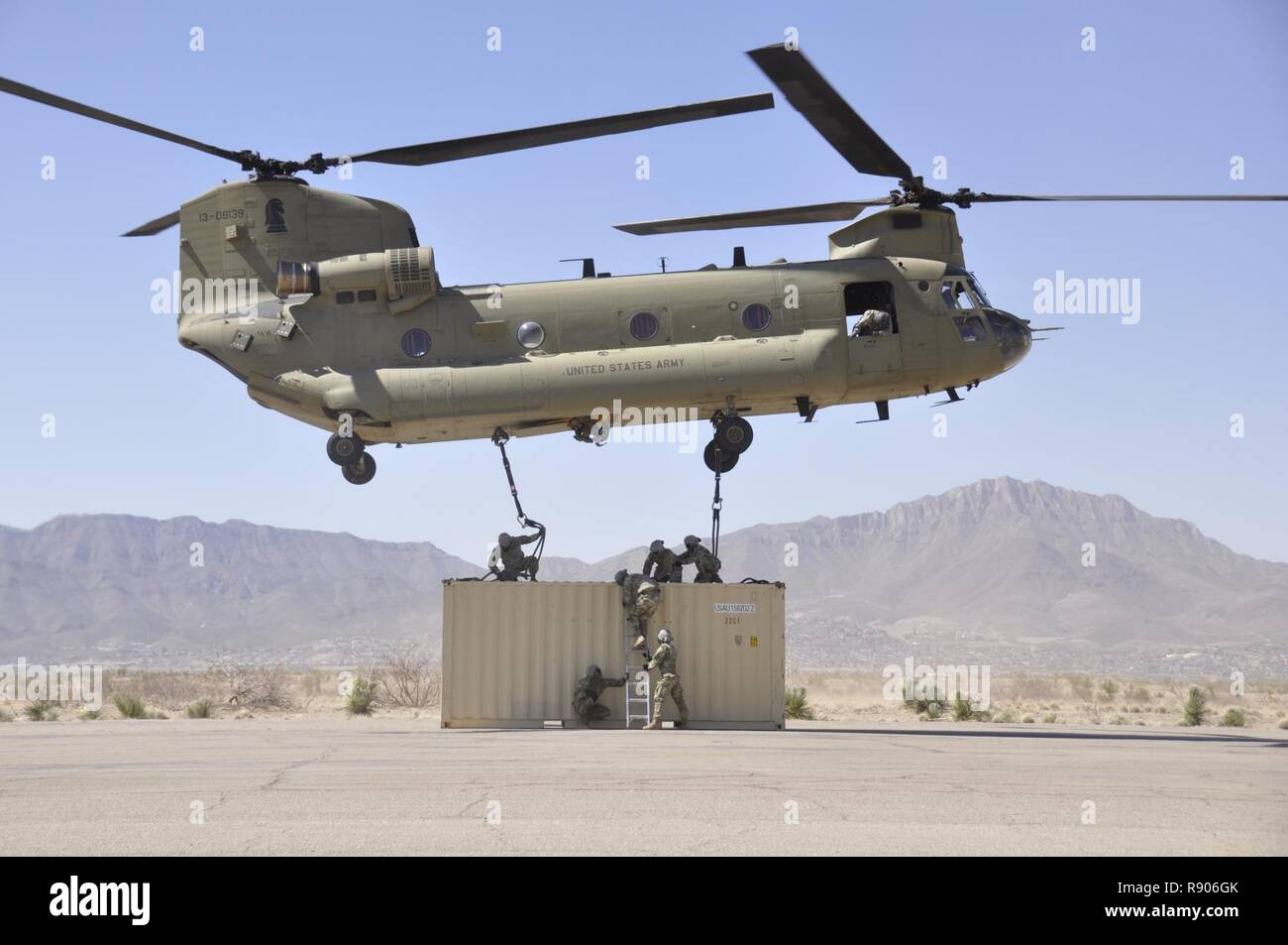 Soldiers assigned to Headquarters and Headquarters Company, Special Troops Battalion, 1st Armored Division Sustainment Brigade, attach a Conex box to a CH-47 Chinook during sling load training at Biggs Army Airfield, Fort Bliss, Texas, March 10, 2017. Stock Photo