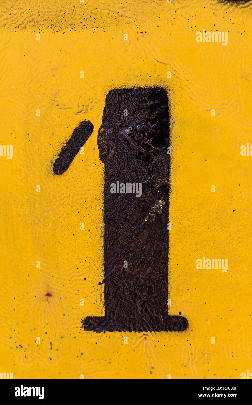 black number stencil painted on yellow background, number 1, number one