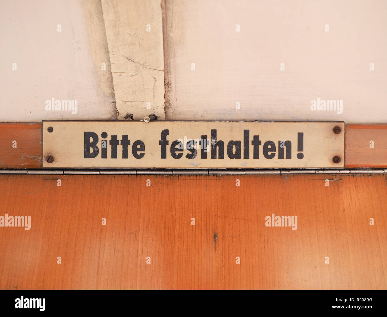 Bitte festhalten (meaning Please hold tight) sign on vintage German tram Stock Photo