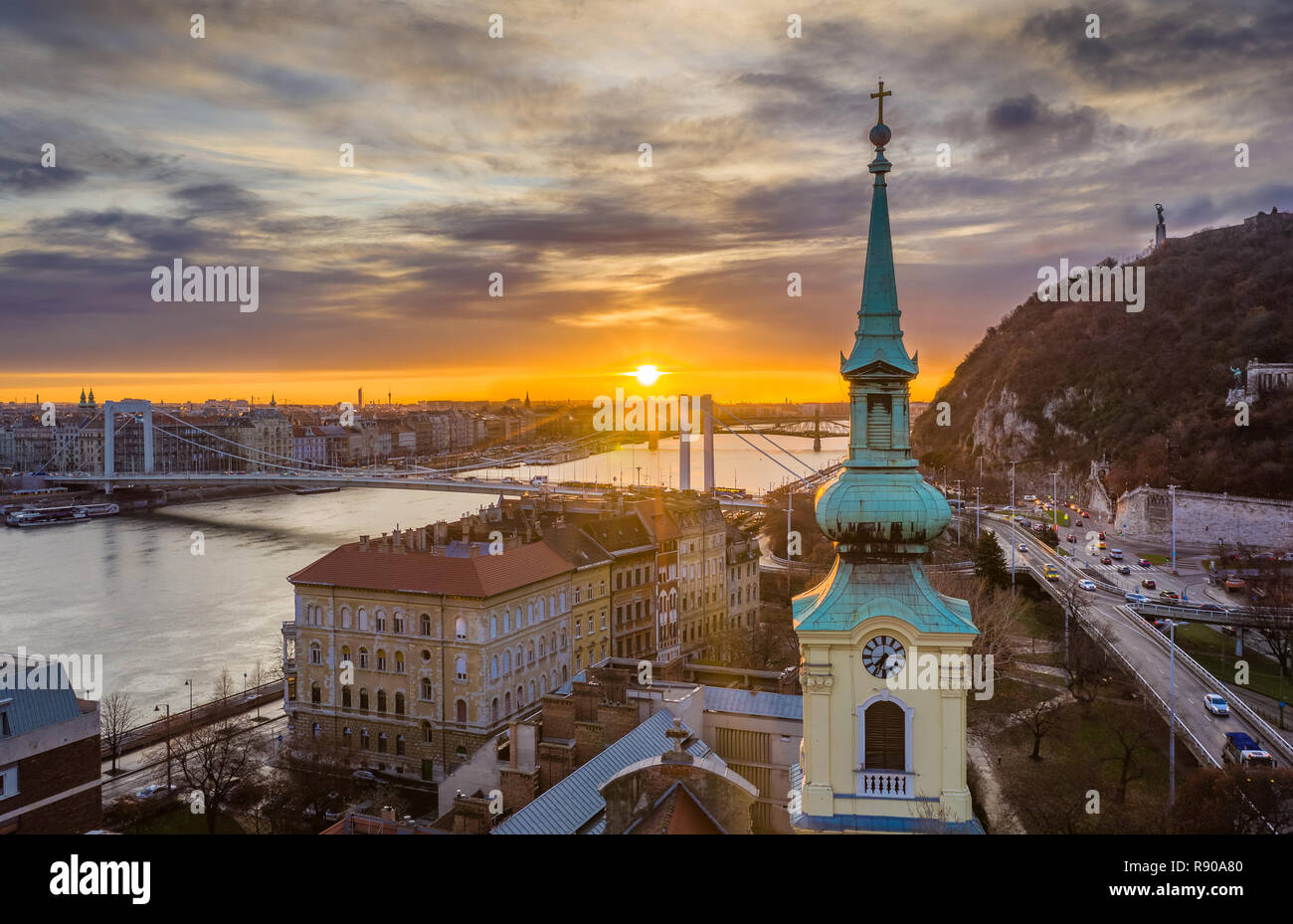 Budapest, Hungary - Church tower and Elisabeth Bridge with a beautiful sunrise over Budapest Stock Photo