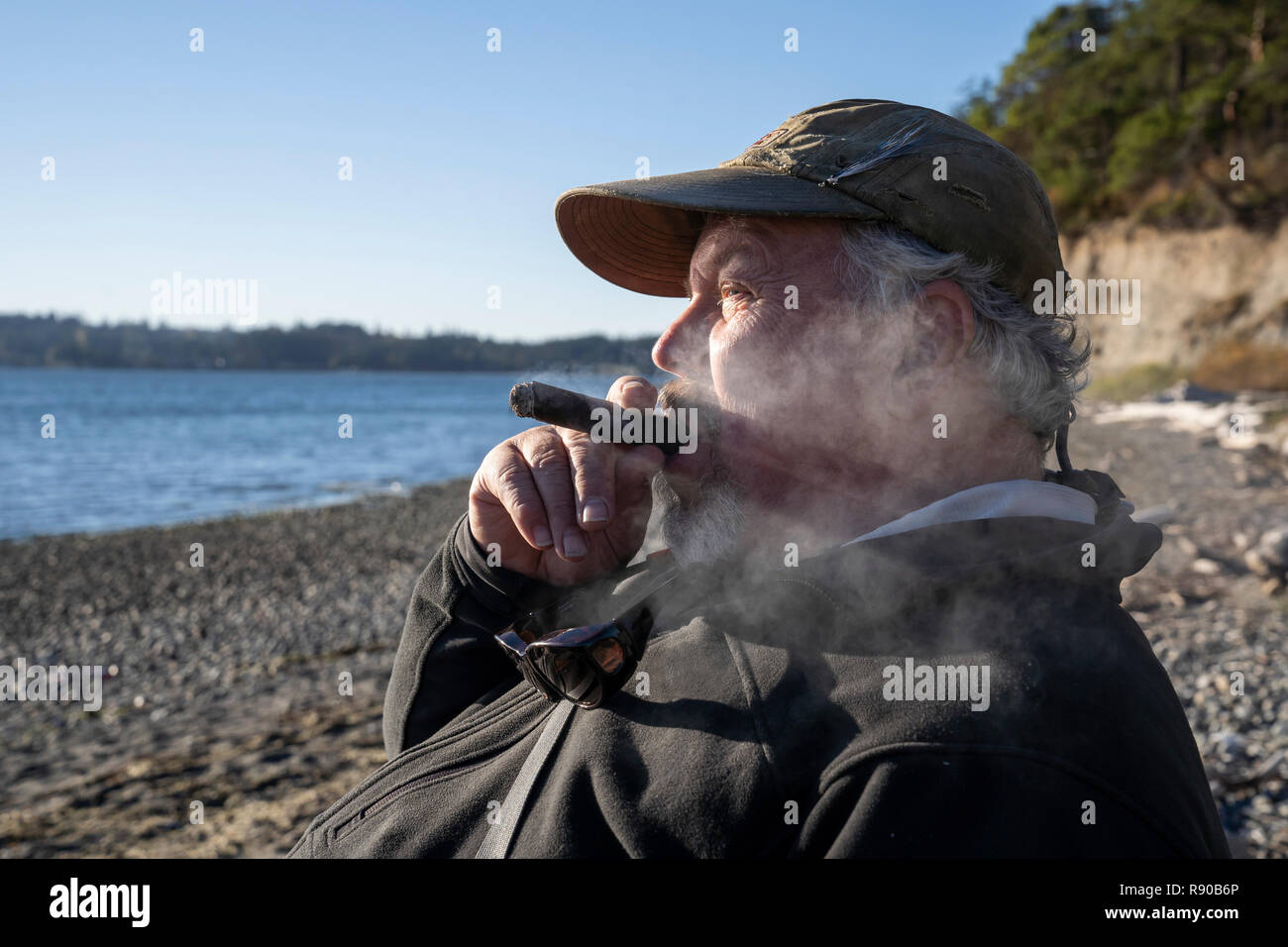 A fly fisherman enjoys a cigar and takes a break from fly fishing for