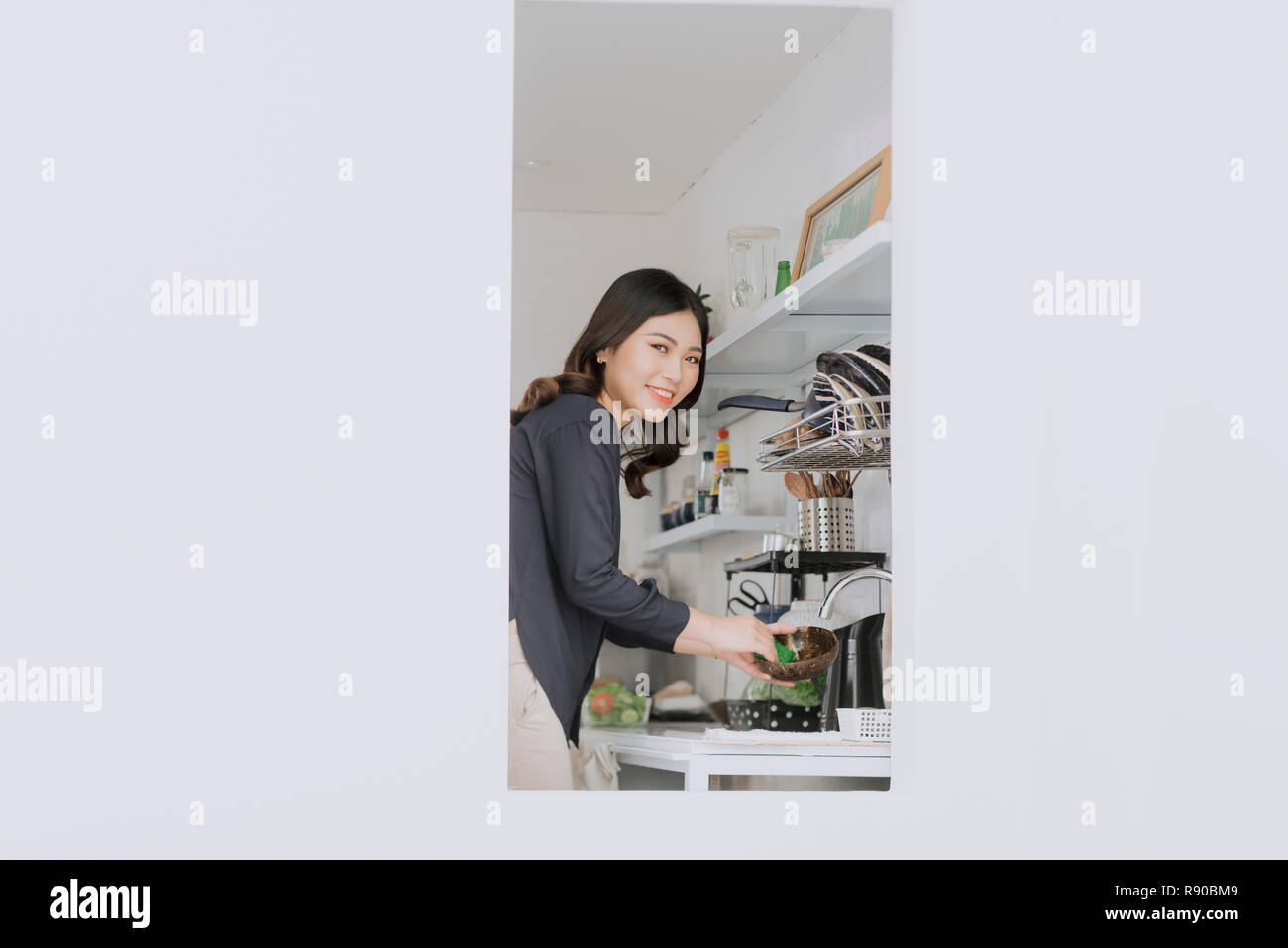 woman without gloves or washing dishes with a sponge. gel and foam for washing dishes. dirty dishes in the kitchen. Stock Photo
