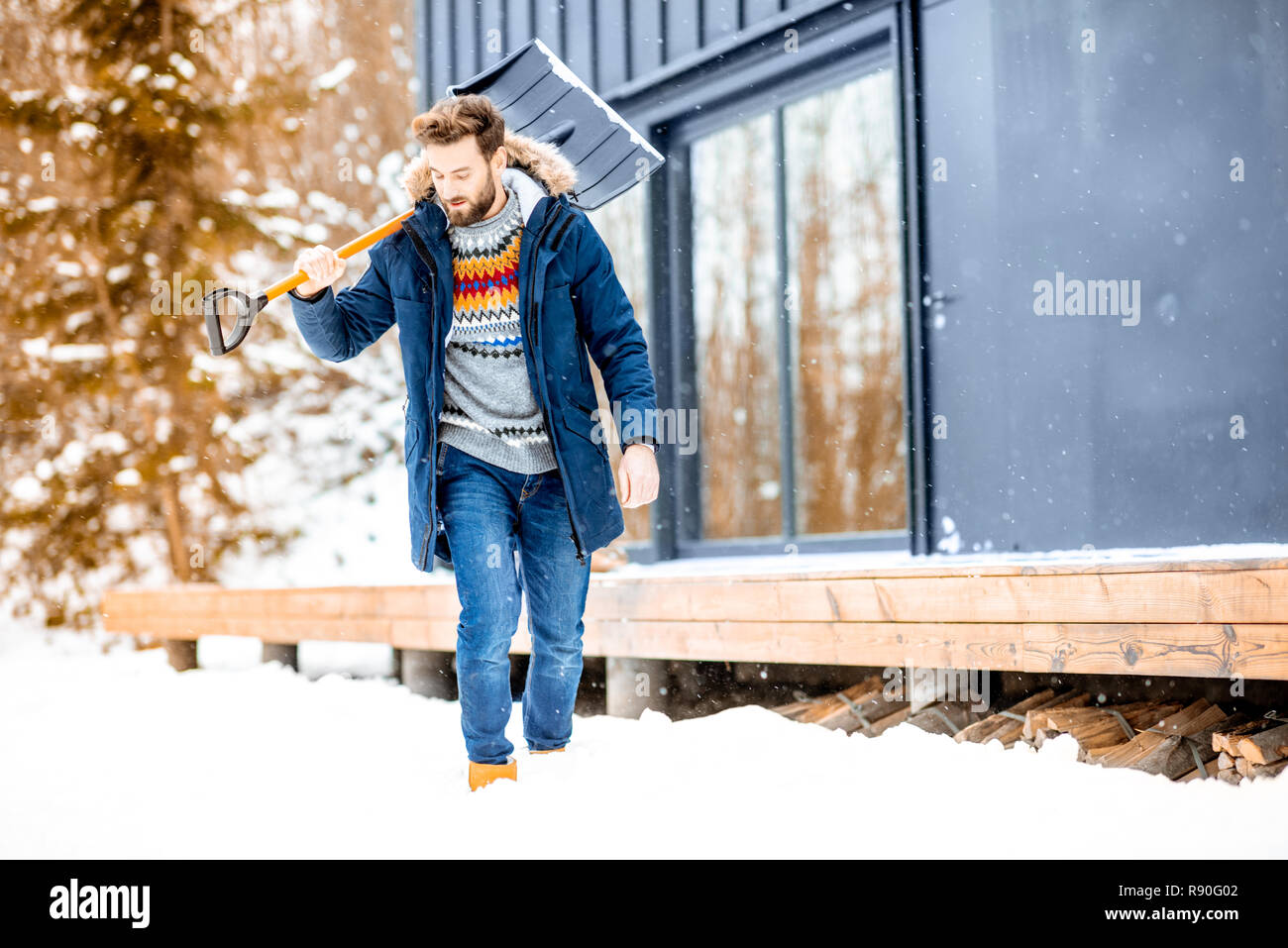 https://c8.alamy.com/comp/R90G02/portrait-of-a-man-in-winter-clothes-with-a-snow-shovel-near-the-modern-house-in-the-mountains-R90G02.jpg