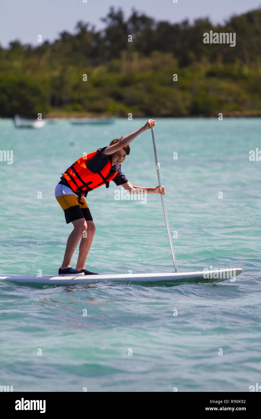 Young boys on stand-up paddle boards with life preservers Stock Photo