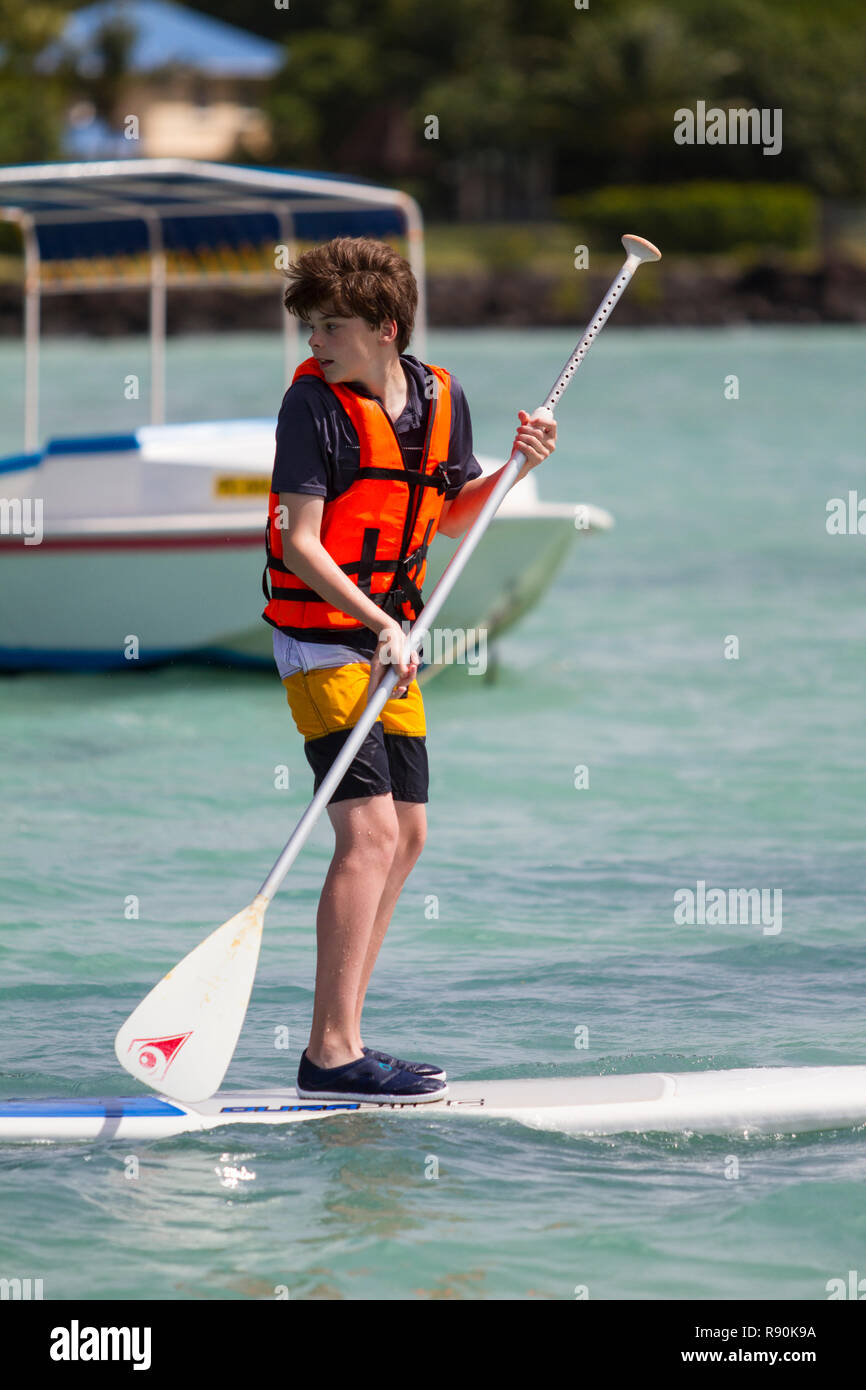 Young boys on stand-up paddle boards with life preservers Stock Photo