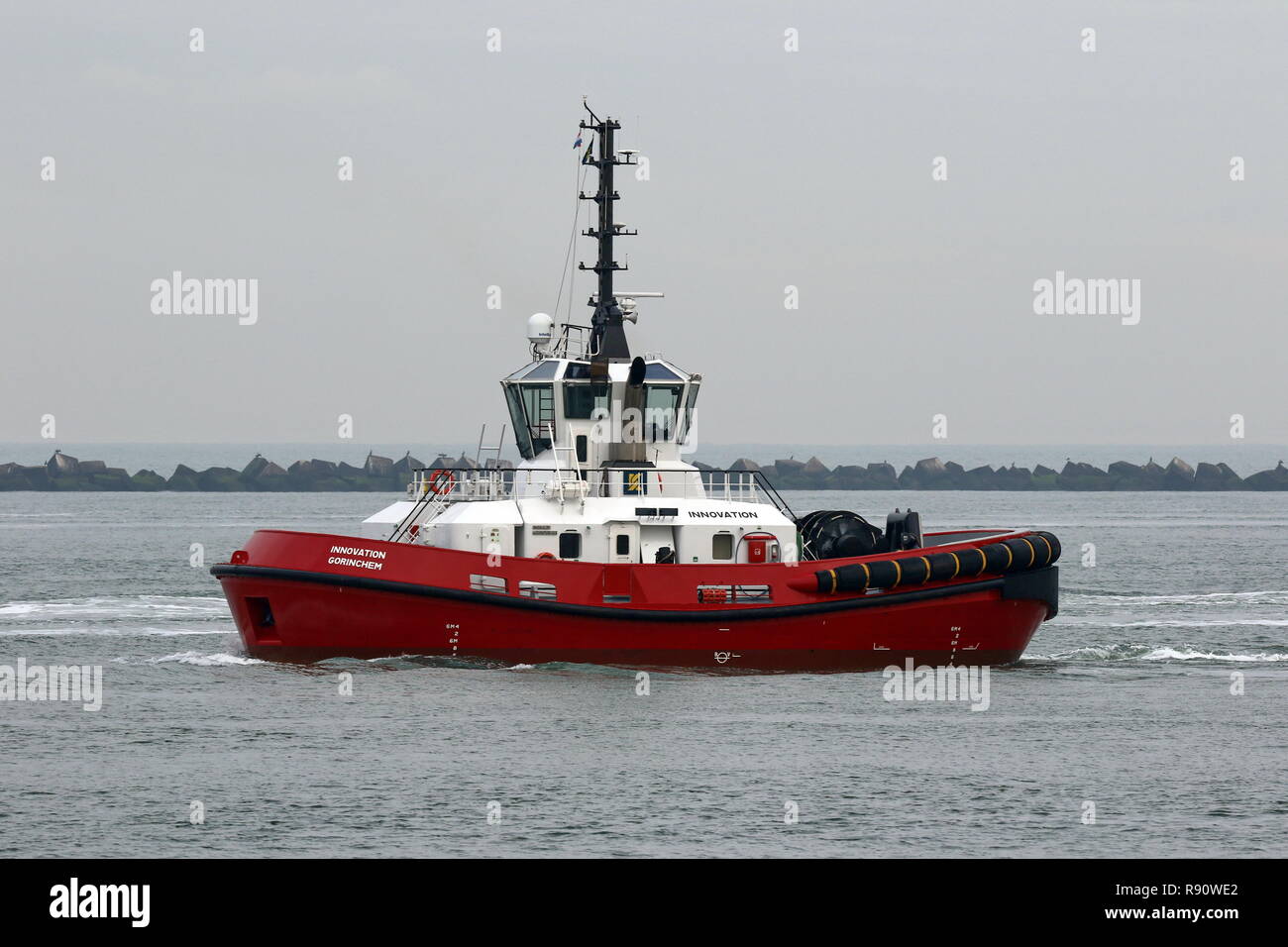 The harbor tug RSD Innovation is waiting on November 23, 2018 in front of the port of Rotterdam on a container ship. Stock Photo