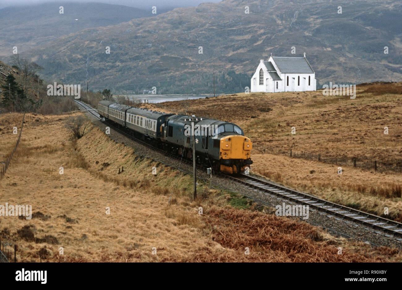 Diesel locomotive passing in front of Lady of The Braes, Roman Catholic chuch, on the West Highland Line,  British Rail Glasgow to Mallaig, Highlands, Scotland Stock Photo