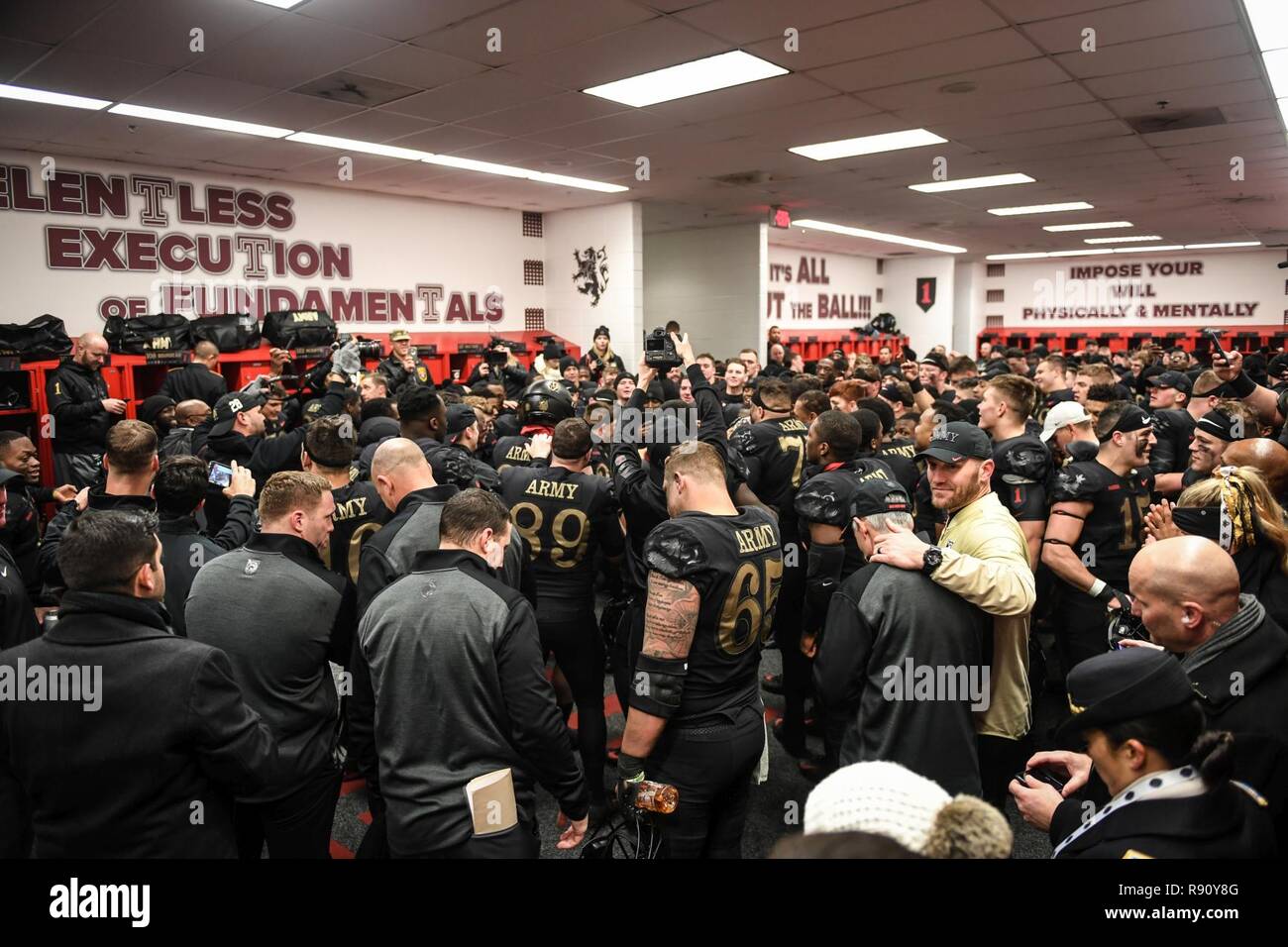 West Point football players huddle up in the locker room during the