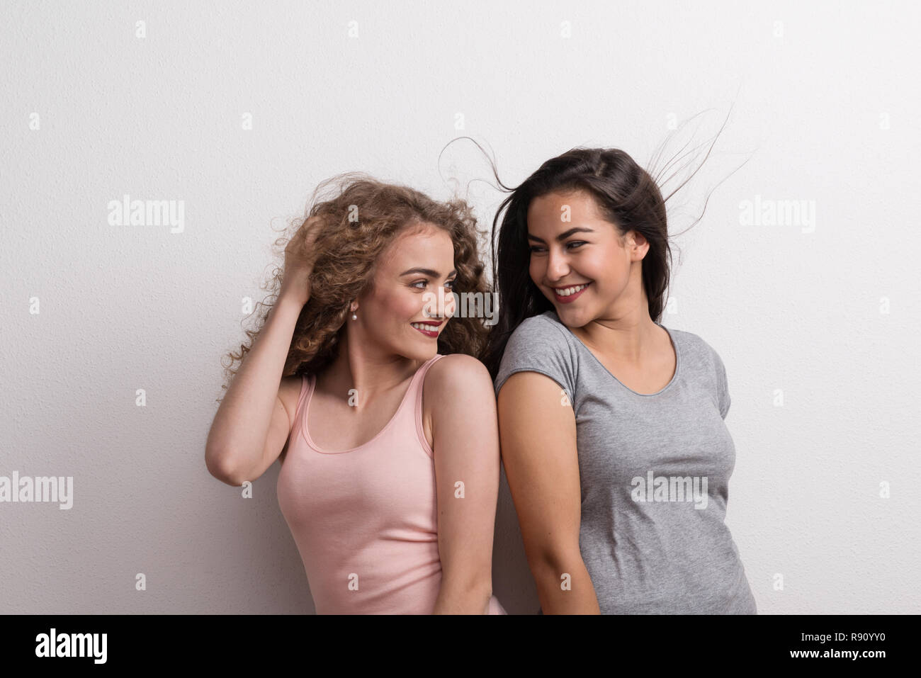 Young beautiful women in studio, looking at each other. Stock Photo