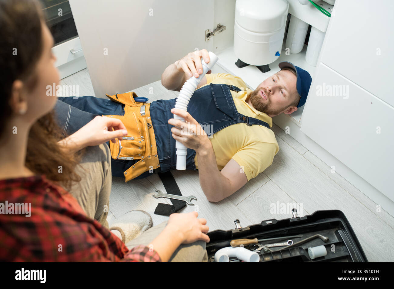 Young plumber changing trap under sink Stock Photo