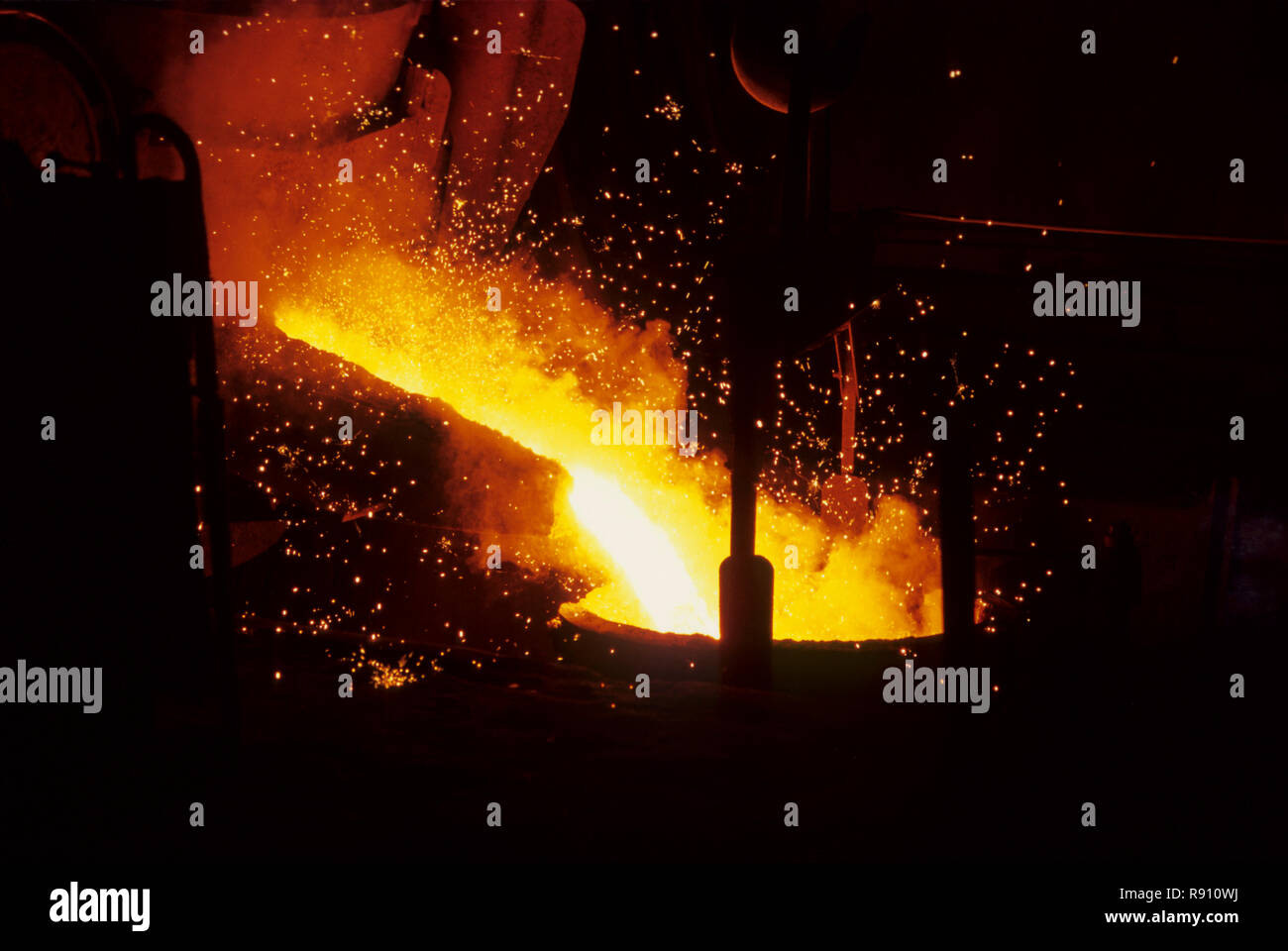 Steel plant, Pouring molten yellow metal in foundry Stock Photo