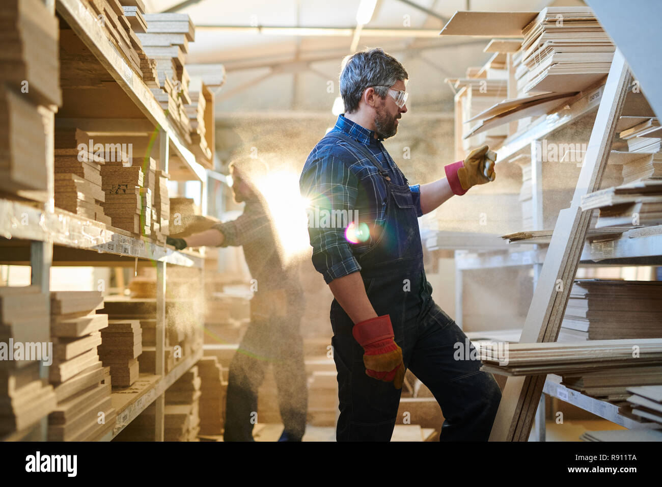 Serious furniture worker finding detail at warehouse Stock Photo