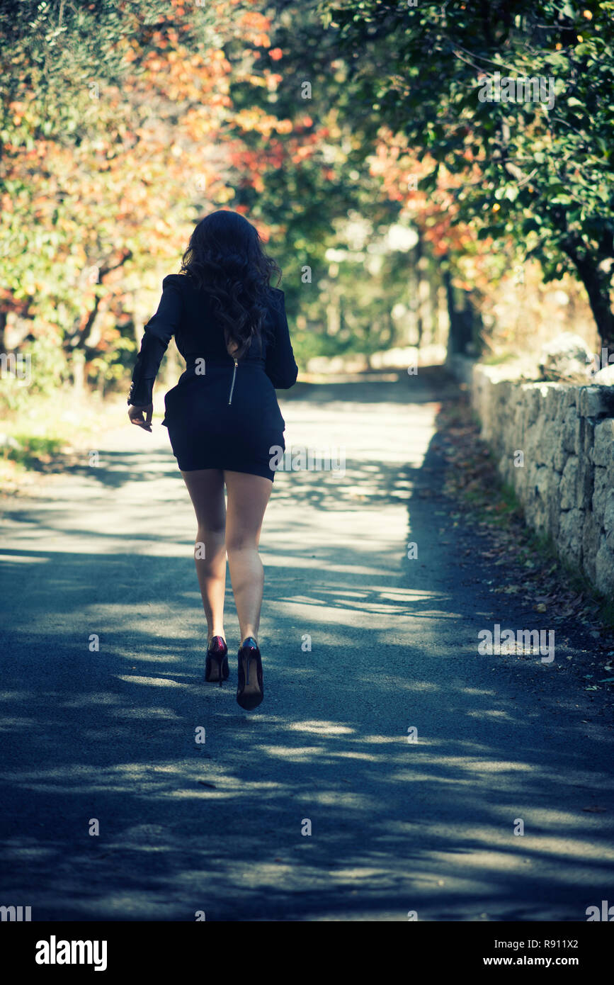 Rear view of a woman running away Stock Photo