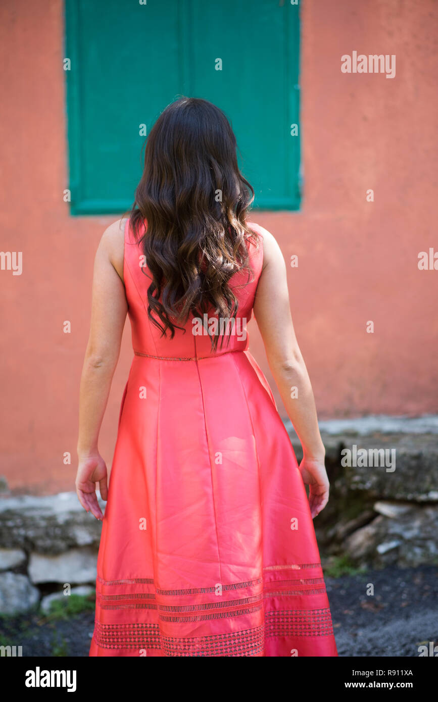 Rear view of a woman standing by the an old house Stock Photo