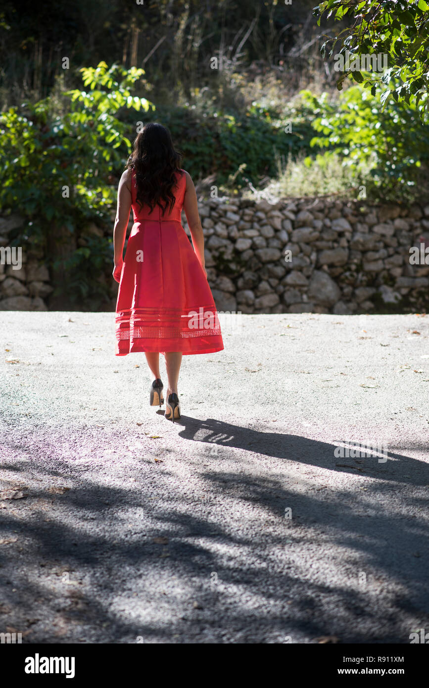 Young woman wearing a dress walking alone outdoors Stock Photo