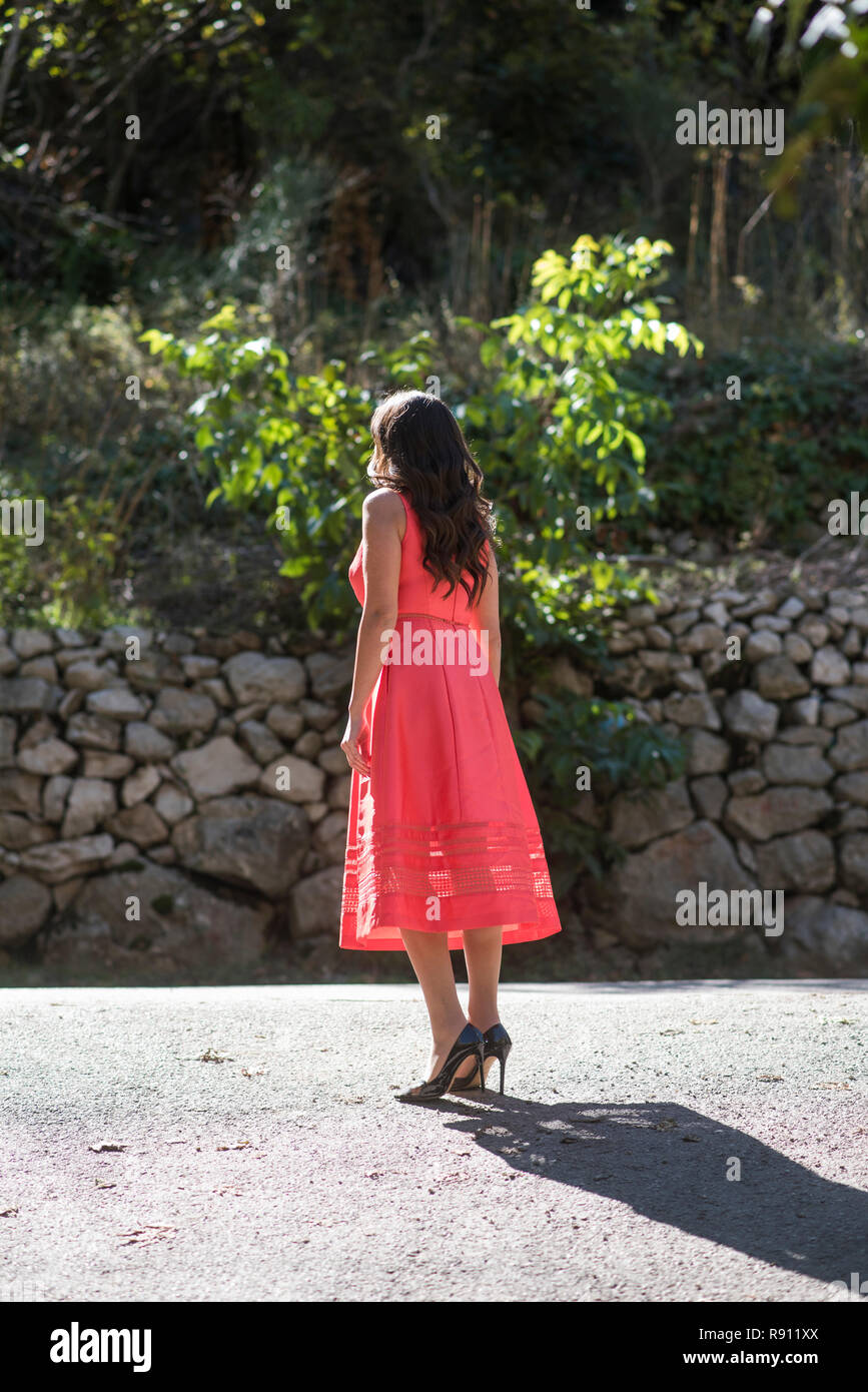 Young woman wearing a dress walking alone outdoors Stock Photo