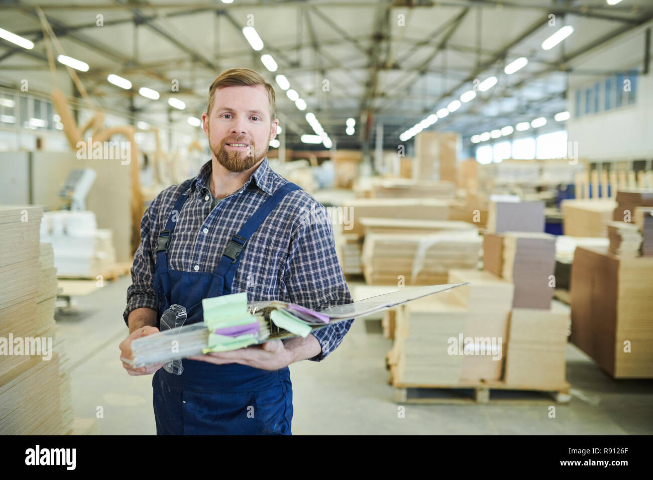 Smiling factory inspector holding folder Stock Photo