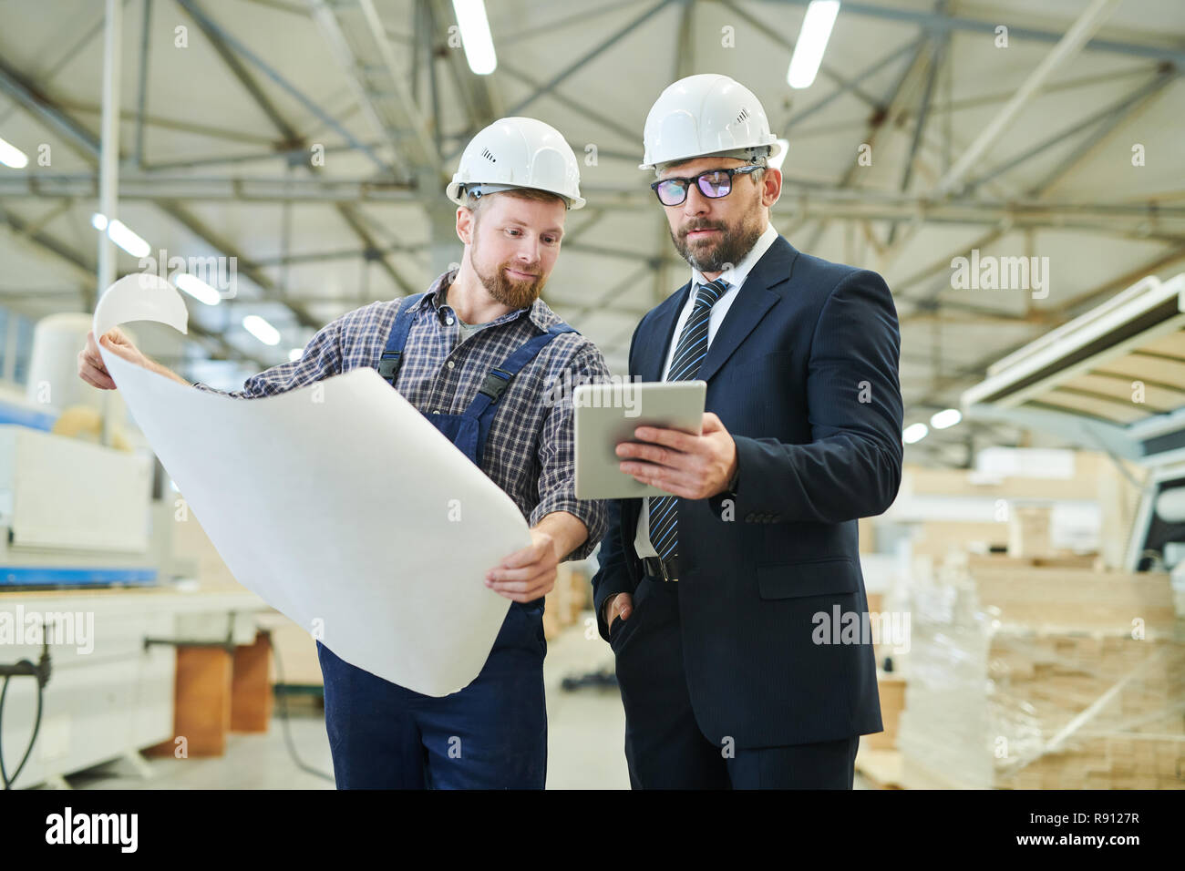 Handsome investor showing online data to engineer Stock Photo