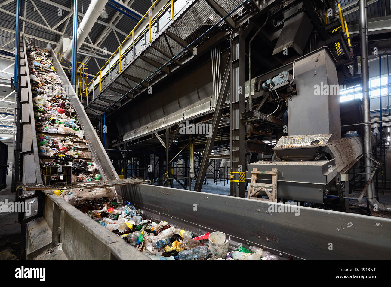 Conveyor belt at recycling plant transports garbage inside drum filter