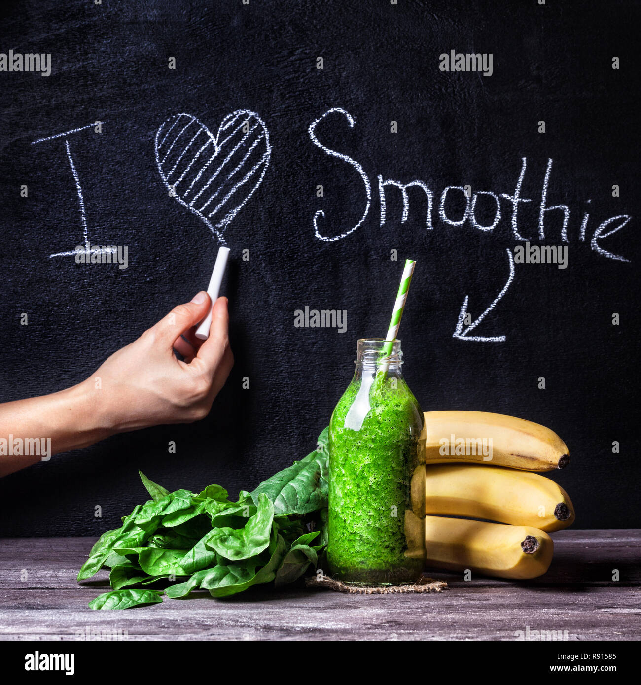 Fresh green smoothie with banana and spinach with title I love smoothie on blackboard Stock Photo