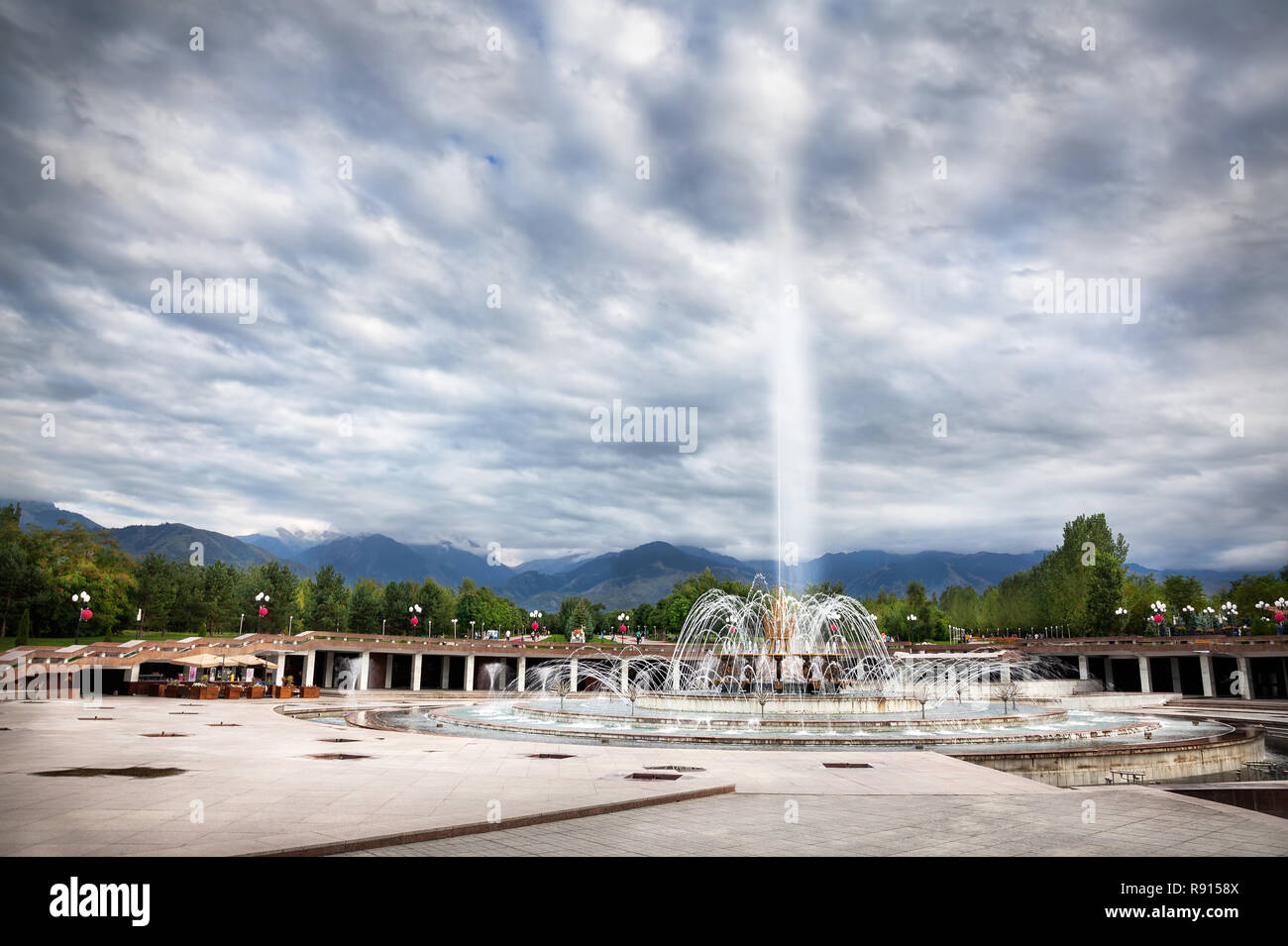 Big fountain at dramatic overcast sky in dendra park of first president Nursultan Nazarbayev in Almaty, Kazakhstan Stock Photo