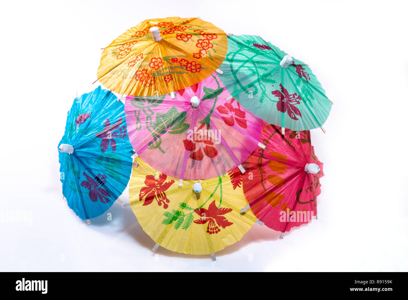 Group of paper cocktail umbrellas on a white background. Stock Photo