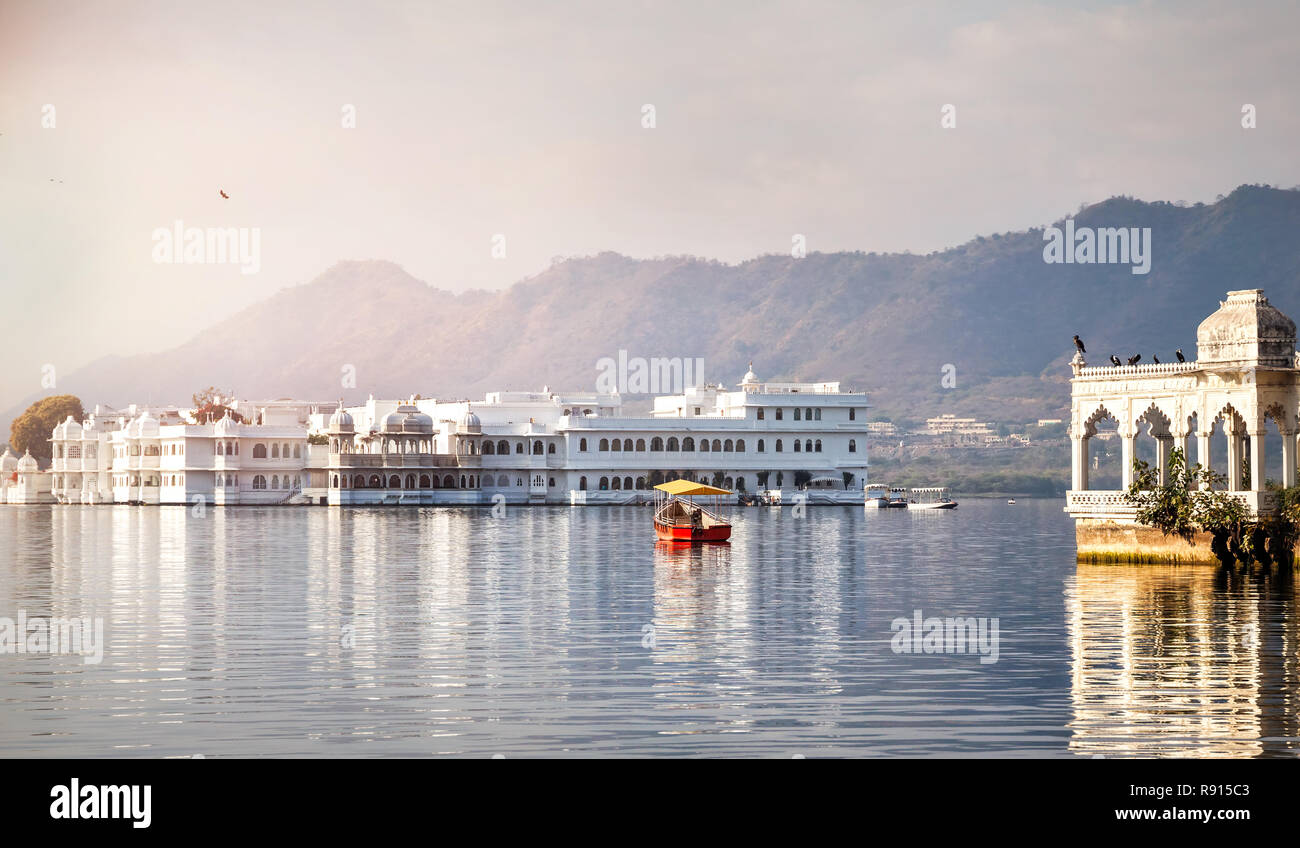 White palace and boat on Lake Pichola in Udaipur, Rajasthan, India Stock Photo