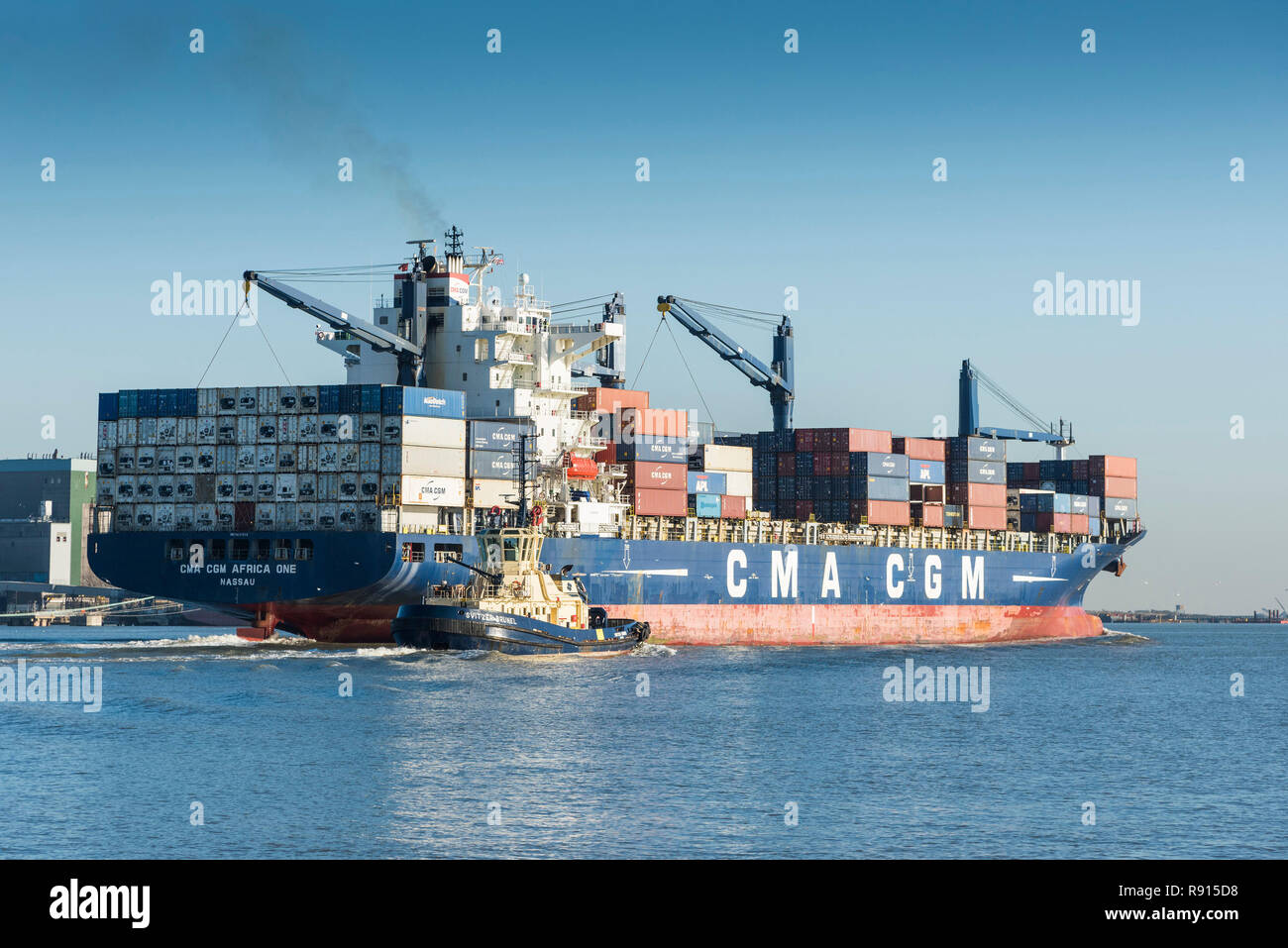 Shipping on the Thames. The CMA CGM Africa One container ship accompanied by the tug Svitzer Brunel steaming downriver on the River Thames. Stock Photo