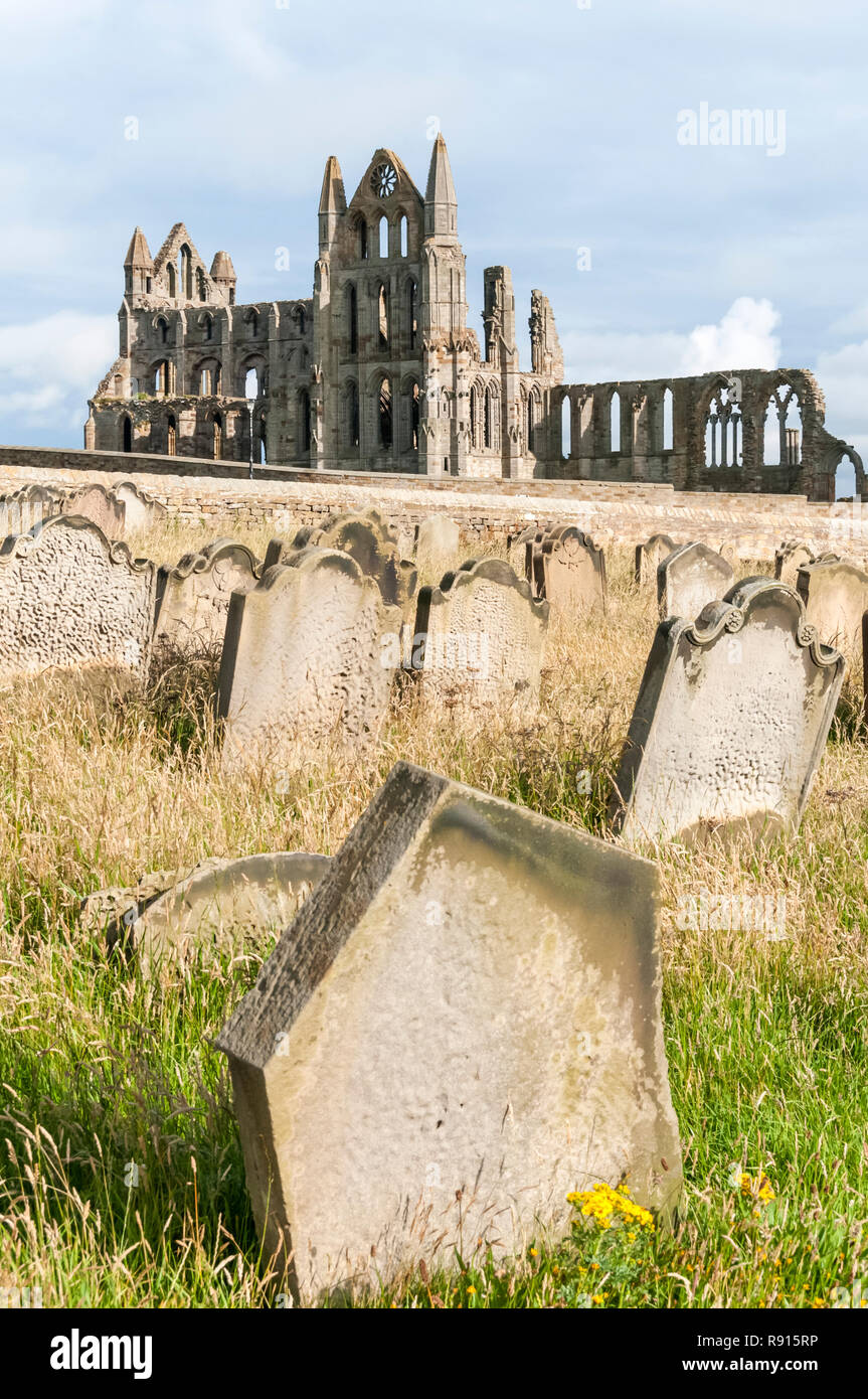 The ruins of Whitby Abbey seen across gravestones in the churchyard of St Mary's church. Stock Photo