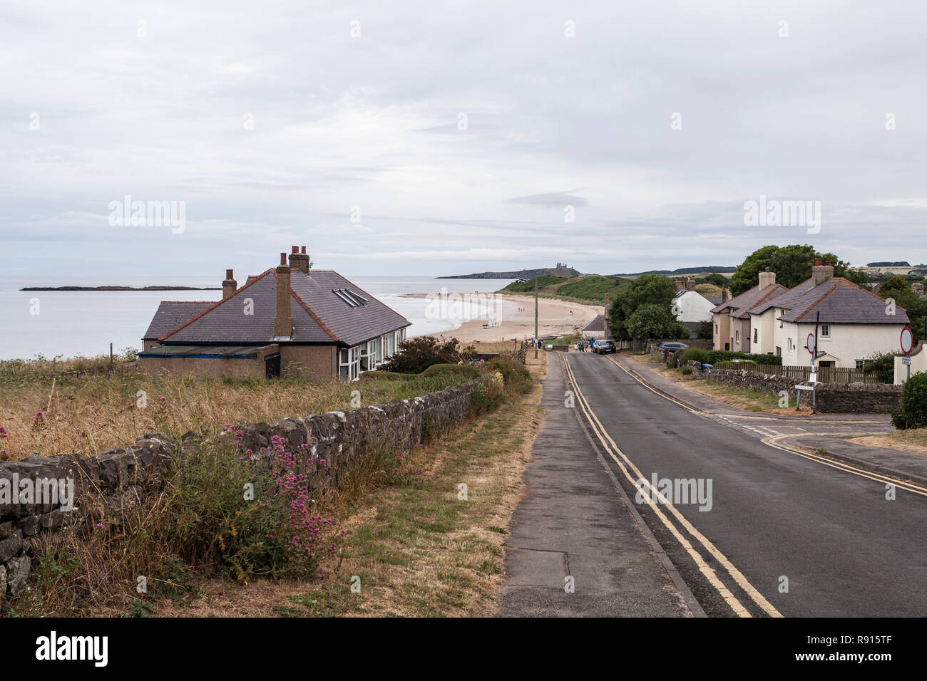 The approach road to the beach at Low Newton by the Sea,England,UK with Dunstanburgh Castle in the background Stock Photo