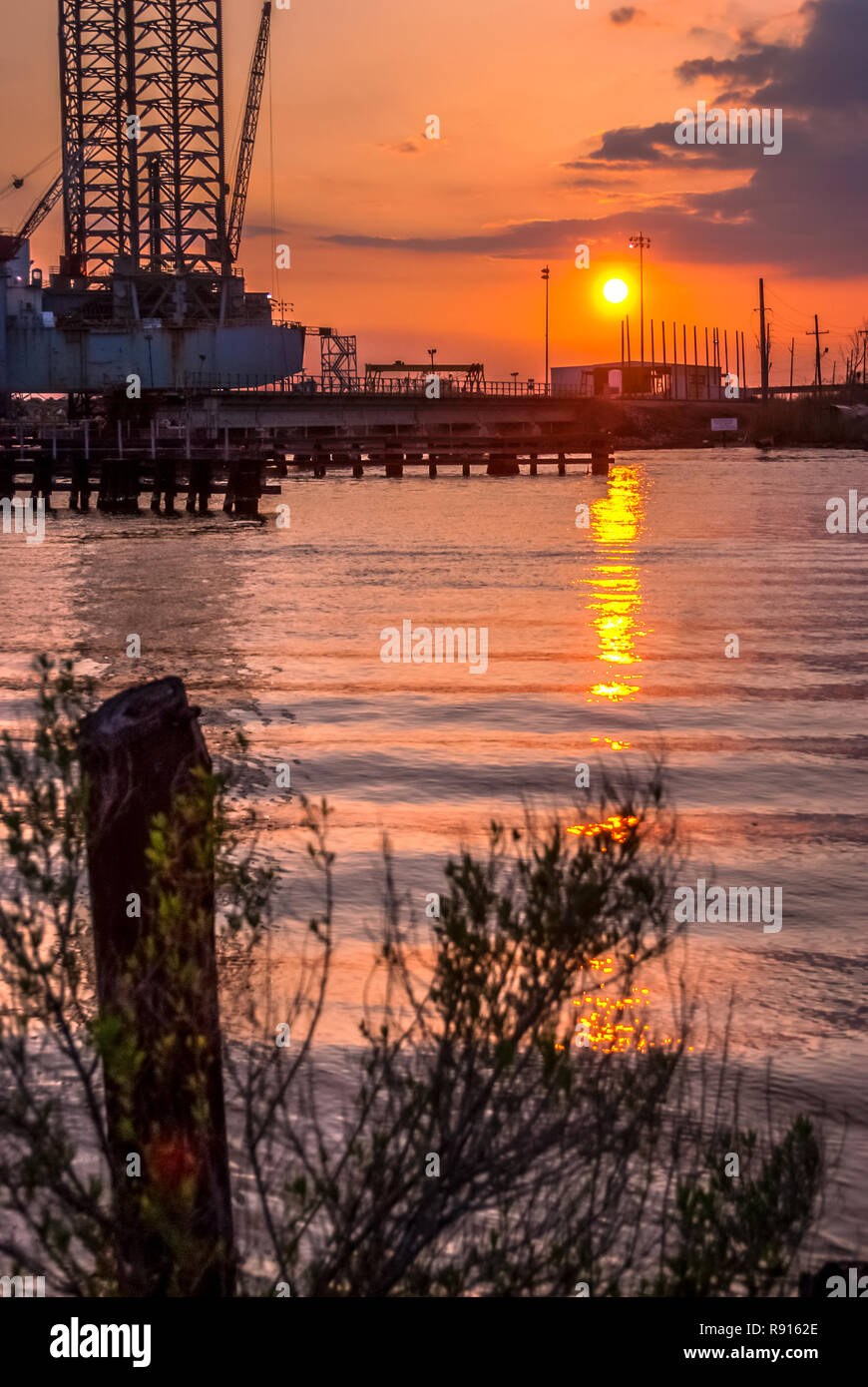 The sun sets over the East Pascagoula River and the CSX railroad bridge, March 18, 2010, in Pascagoula, Mississippi. Stock Photo