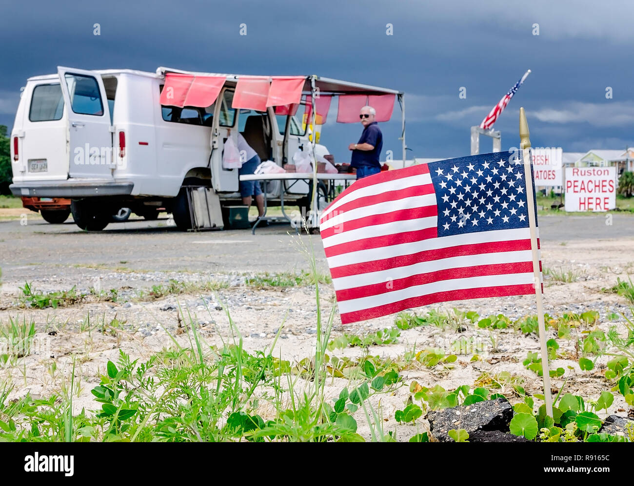 American flags fly at Paul Verzwyvelt’s roadside fruit stand, June 12, 2018, in Pass Christian, Mississippi. Stock Photo