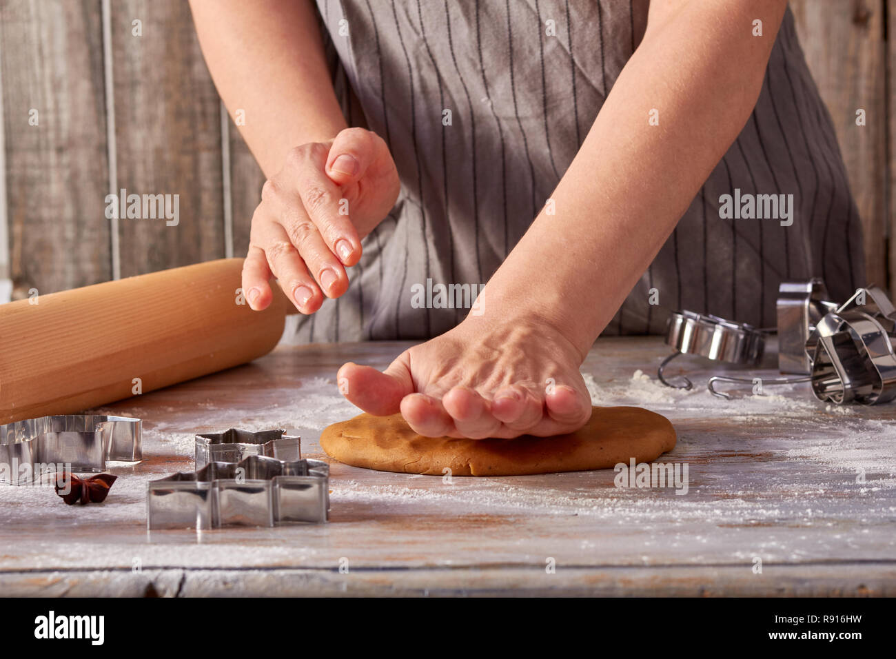 Woman hands rolls up the gingerbread dough on the table Stock Photo