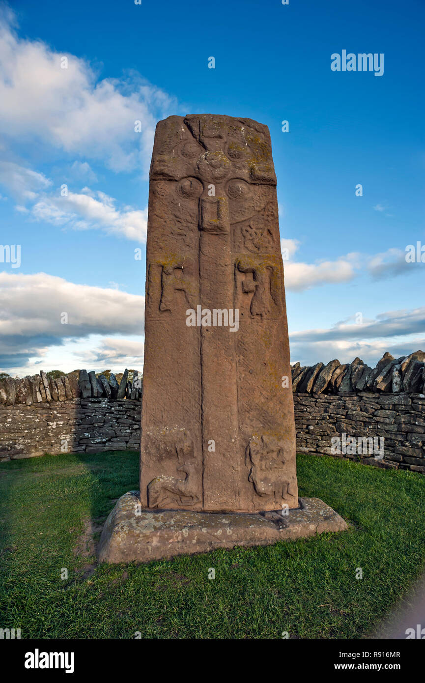 Early Medieval Standing Stone, The Roadside Cross.  by roadside at Aberlemno, Angus Scotland UK against a bright blue cloudy sky Stock Photo
