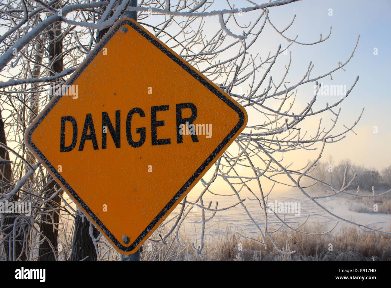 Danger sign, forbidding entered the frozen river in winter covered with snow at minus 15 degrees below zero on the banks of the Saint-Laurent river. Stock Photo