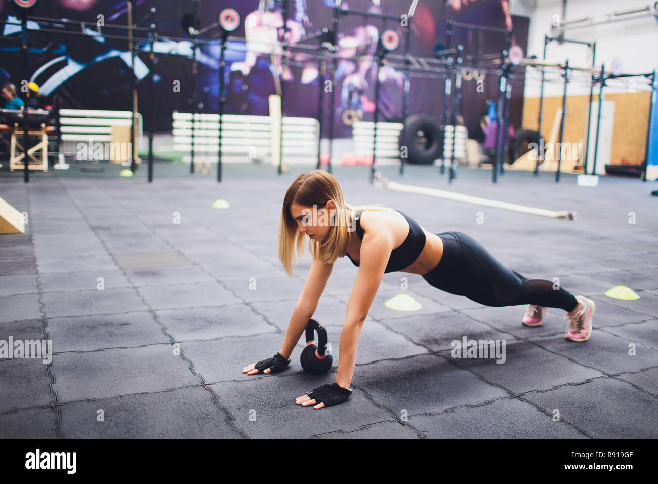 Young sporty woman stretching legs in gym. Stock Photo