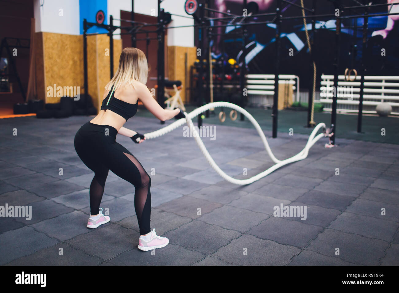 Strong woman exercising with battle ropes at the gym. Athlete doing battle  rope workout at gym Stock Photo - Alamy