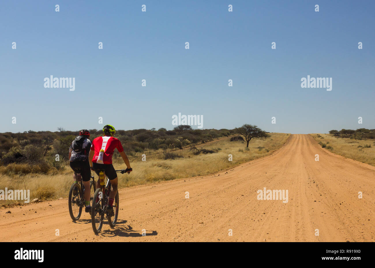 cyclists on MTB or ATB off road bike on dirt road in African landscape in Namibia Stock Photo